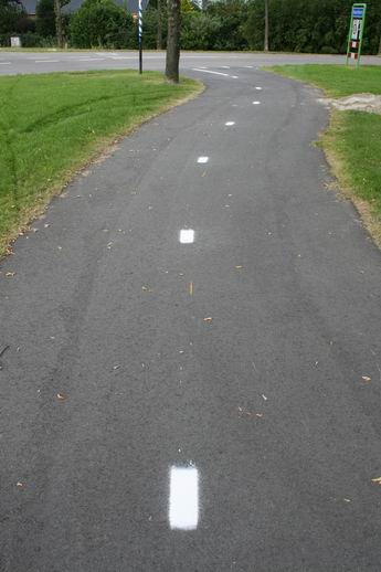En het resultaat? Keurige, korte witte strepen op het fietspad, ook langs de N355. Dat is in de schemering of in het avondduister toch wel handig, voor fietsers en wandelaars. De racende bromfietsers zien waarschijnlijk een lange doorgetrokken streep....  