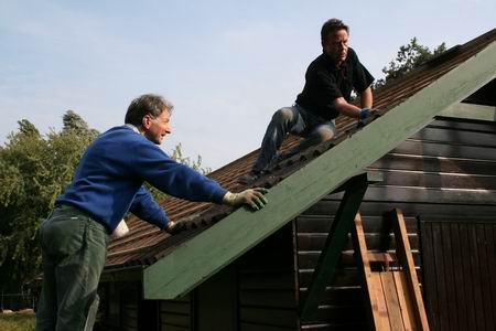 Het duo Hans & Hans als dakpannendeskundigen op niveau. Hans de Boer geeft aan en ziet dat zijn maat Hans Pinkster secuur legt. Nauwkeurig werkje!