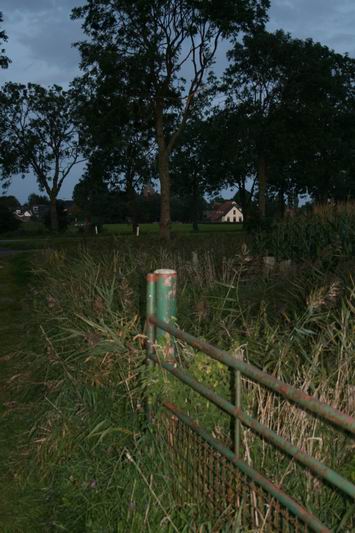 Hek bij oude heirbaan ter hoogte van de N355, met flitsgebruik. Zicht op het dorp met opvallendste punt het huis van de familie Achterhof. Septemberavond, tegen acht uur.  
