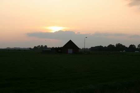 Het beeld dat je tegen de avond ziet, als je Noordhorn uitloopt via de Langestraat Noord en de N355 oversteekt. (Pas op, weer zo'n snelle jongen.....) Ondergaande zon boven Oxwerd. Centraal de schuur van Jan Tempel.