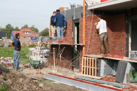 Een vrijdagmiddagbeeld van het metselen aan het woonhuis van de familie Kooi (Meidoornstraat 22). Heerlijk, die gunstige weersomstandigheden, zo kun je opschieten!  