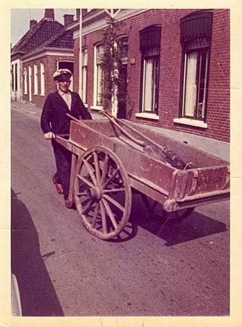 Jan Vennema sr met de handkar en gereedschap in de Langestraat. Waarschijnlijk is dit geen foto uit het werkend bestaan, maar een kiekje ter gelegenheid van een feestelijke gebeurtenis... 