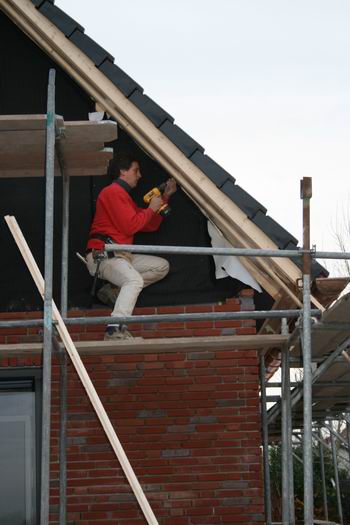 Marco Kooi bereidt het laatste metselwerk voor, de puntjes op de i. Ook de dakgotenbouwer is nog niet klaar, maar de pannen liggen beschermend op het fraaie pand.  