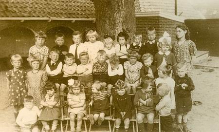Een grote groep kleuters met juf Zaagman, de foto is genomen in 1942, achter de toenmalige Nutskleuterschool aan de Achterweg.