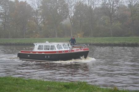 Daar is ie al, de motorboot, met de schipper groot in beeld. Maar wie heet er nou Roodhals?  