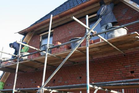 De metselaars maken het metselwerk aan de westelijke topgevel af van Marco Kooi zijn huis. 