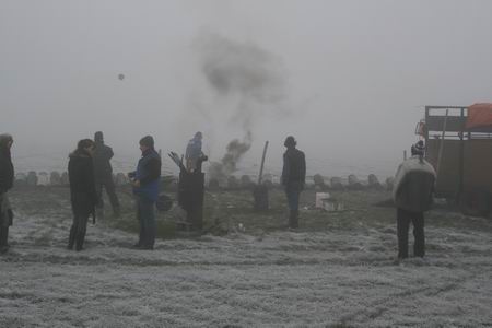 De mist maakt het wazig, maar af en toe vlamt het, stijgt er een rookwolk op, knalt het met doffe dreunen... Jongeren die zonder al te veel woorden hun taak uitvoeren, verantwoord. Vader Klaas Tempel houdt twee oogjes in het zeil... 