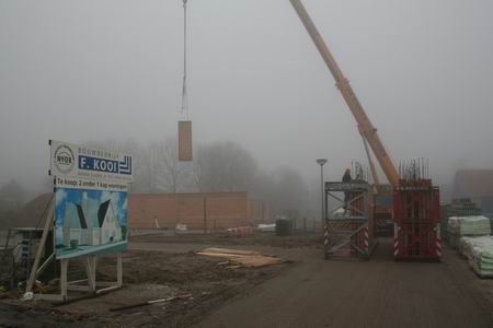 Op de acht kavels van de firma F.Kooi worden de prefabmuren keurig op rij geplaatst. Vandaag zijn de luxere woningen op 6 en 8 aan de beurt. 