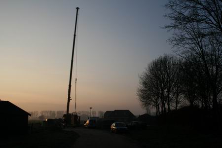 Trage zonsopkomst met hijskraan aan de Meidoornstraat in Hamsterpad III. De prefabdelen van de starterswoningen worden in elkaar gepast.