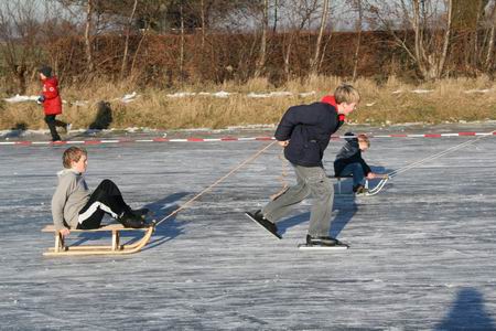 Jeugd die zich vermaakt met het sleetje trekken en het voortgetrokken worden...   