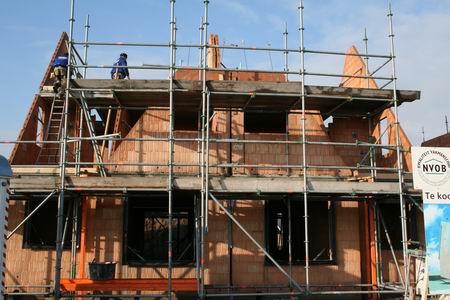 Enkele Kooiklussers in hogere sferen om het plaatsen van de prefab dakdelen voor te bereiden  