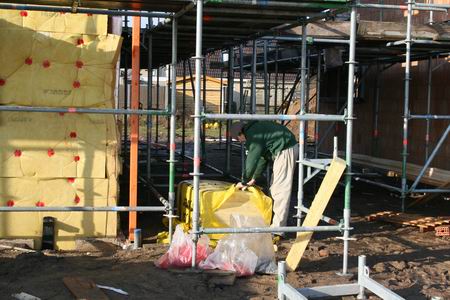 Een andere Kooiman pakt de skeletten in met isolatiemateriaal  