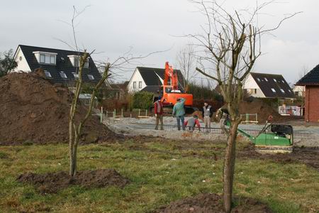 Op de meest zuidelijke bouwkavel, die van de familie Heeres, wordt ontspannen gewerkt aan het fundament. De toekomstige eigenaar is even te gast en helpt een handje mee 