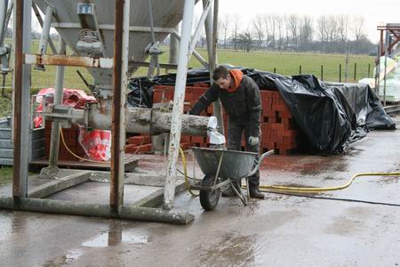 Een Stratingwerker verzorgt het transport van de specie per kruiwagen vanf de silo. 