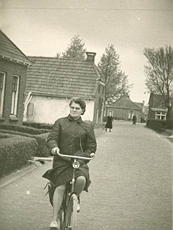 Mevr.Overkamp-Helmholt, eveneens op weg naar het stembuslokaal in de OLS. Links het deel van het dubbele huis, afgebroken, waar Nijenhuis woonde. Verderop het huisje van Wobbe Jonkman, dicht op de straat, zoals toen in Noordhorn vaker voorkwam.