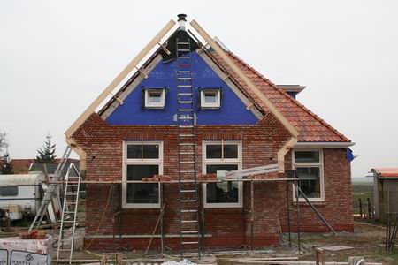 Het huis van Alex Zwama, waar het blauw langzaam verdwijnt achter een eigenzinnig gemetselde gevel  