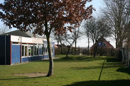 Ook de zuidkant van CBS het Kompas geniet van de zon, en staat een doorkijkje toe naar huize Zwama 
