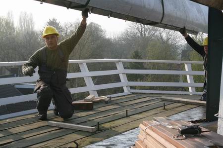 De Jellemakundigen nemen de delen van de wieken in ontvangst op de molenomloop 