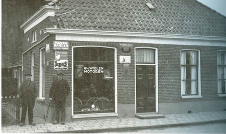 resize-of-langestraat14gisteren Nog een afbeelding uit GISTEREN VOOR DE LENS (blz.136). Dit is Langestraat 14, woonhuiswinkel van smid Fokkens, die links naast het pand staat. (De andere man is R.van der Noord). Na Fokkens vestigde Klaas Kaspers zich hier, al gauw verhuizend naar de overkant. In Langestraat 14 kwam toen melkhandel Meerveld, later de familie Boonstra.