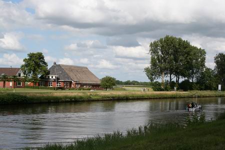 Bekeken vanaf de zuidkant van het kanaal: verdwijnend bootje, boerderij van Agema, woning van de familie Faber, voorheen Vennema... 