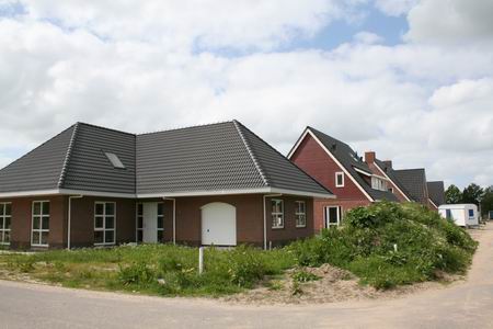 Henk Bakkers pand gaat verscholen achter bulten grond met (voor plantenliefhebbers) boeiende begroeiing. 