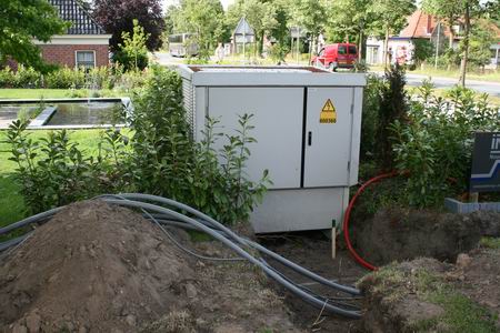Het kleine schakelstation in de hoek van de voortuin, wonder der techniek. Aansluiten dan maar, grond erover en na verloop van tijd weten we niet beter dat... 