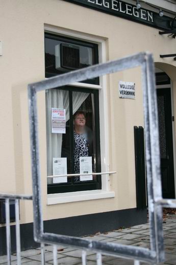 Waardin Tieneke van der Veen-Pijpker met een zorgelijke blijk achter het raam van café Welgelegen, kijkend naar het weghalen van de wieken van de molen in november 2008. Als dat maar goed gaat.... 