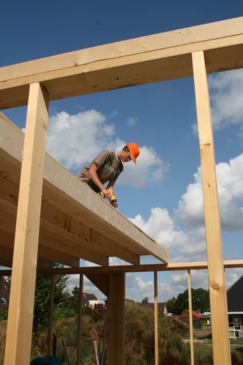 Vakman in de dop, Arjan, bezig met de bouw van de nieuwe garage bij nummer 22
