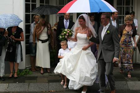 Daar gaan ze, Marleen en Henk, welwillend en vertederd gadegeslagen en gevolgd door familie en vrienden.. En de grote paraplu? Spontaan beschikbaar gesteld door een belangstellende... Proficiat, Marleen en Henk! Geluk zij jullie deel, van harte gegund!