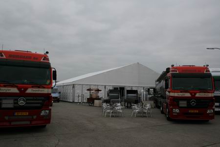 Een grote tent, waarbinnen nog hard wordt gewerkt om alles op tijd klaar te krijgen voor het officiële gedeelte, de ontvangst der gasten, de toespraken, de hapjes en de drankjes...