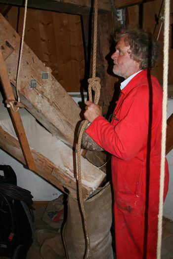 Molenaar Drewe Schouten geconcentreerd aan de slag; hij regelt de afstand tussen de maalstenen (als ik het goed heb begrepen, ik ben en blijf een leek...) 