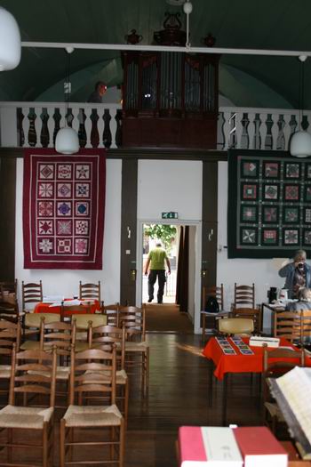 Het interieur van deze kleine, maar knusse doopsgezinde kerk is speciaal voor deze gelegenheid opgefleurd met QUILTEN van Gaatske Geertsema-Jager, fervent handvaardig bezig 