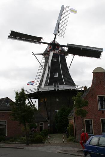 Molenaar Drewe Schouten bekijkt de fraai ogende molen eens even vanaf de buitenkant. (Molenaar Klaas Hekker regelt binnen de koffieverstrekking). Hoewel de werkzaamheden niet helemaal zijn afgerond, ziet de molen er steeds 'opgeknapter' uit!