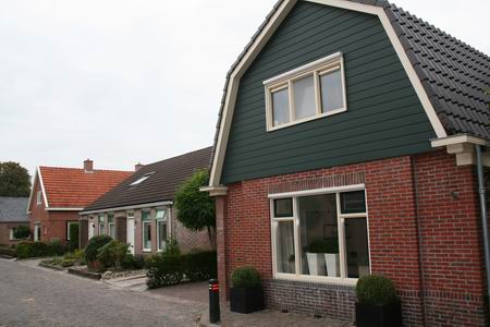 Zelfde deel van de Oosterweg, maar nu vanaf de zuidwestkant. Op de voorgrond het woonhuis van de fam.G.Burgler tot 1955. Het huis is grondig verbouwd, van gezicht veranderd...  