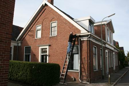Ladderbeklimmer Reeuwert Nanninga aan de slag met herstelwerkzaamheden aan de zuidkant van het kenmerkende Fleerkamppand, ook aan de Langestraat 