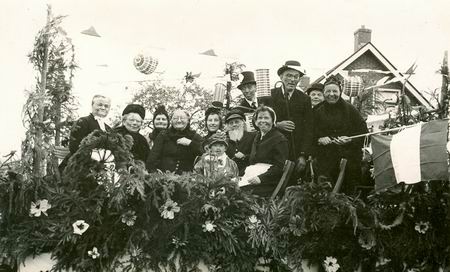 Wie zijn deze verklede feestvierenden op de versierde wagen???