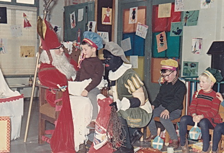 Sint gaat onverdroten verder in een gemoedelijke sfeer, het boek der boeken als onontbeerlijke hulp. En de kleuter met bril, is dat Jan Arends of....?