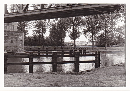 Onderdoorkijkje vanaf de noordoostkant bij de spoorbrug. Op de achtergrond de voorganger van het onlangs gesloten overdekte zwembad "De Waterborgh", openluchtbad "De Dobbe". Illustratie van de ingrijpende veranderingen in een relatief kort tijdsbestek. In dit geval VERSLECHTERINGEN, want het nieuwe overdekte bad (concept Kollum) is geen volwaardig alternatief.