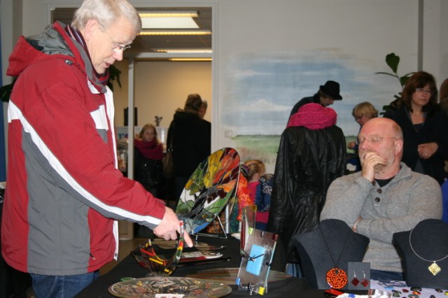 Schilderwerk op glas? Glas in lood? Emailleren? Een kundige kijker en een geïnteresseerde standhouder....
