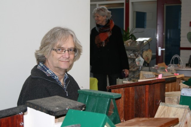 Lokale nestkastenbouwer (en 'golddigger') Herman Scholte presenteert zijn vogelbehuizingen. Herman zit pal voor de uitpuilende prijzenkast van de damclub, stimulerend en afleidend!