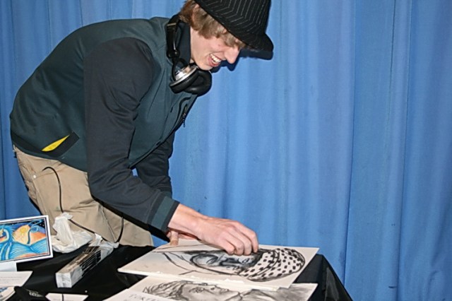 Op het podium is de vaardige sneltekenaar met zijn tekenkunst bezig! "En dat is dan 5 euro...!"