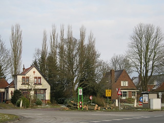Eerst maak ik toch nog maar even een foto van de beide te slopen huizen en het groen eromheen. (En de slordige veelheid aan verkeersborden...)