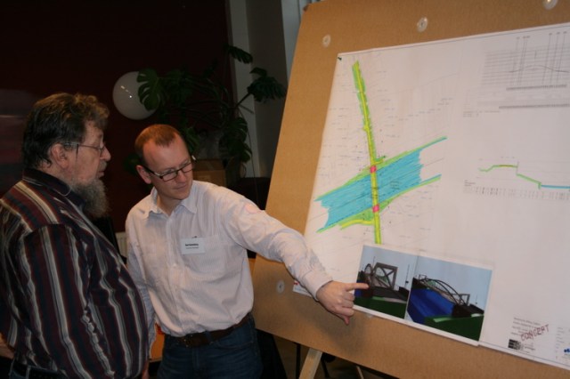 Oud-Dorpsbelangenvoorzitter DJvdBos laat zich in de naar hem genoemde zaal bijpraten over de nieuwe brug. (Nee, die wordt niet naar hem genoemd...)