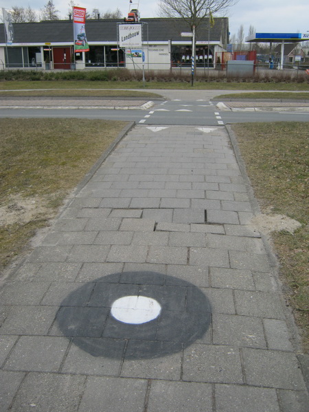 Deel fietspad tegenover Langestraat 9. (Nee, die witte stip lijkt me niet bedoeld als waarschuwing tegen de al maanden in struikelpositie verkerende tegels...)