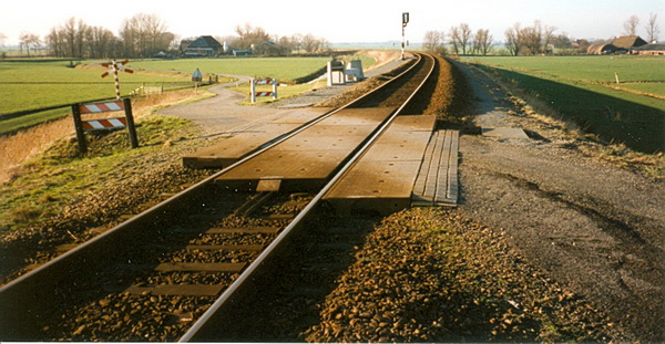 Foto gemaakt door Piet Niemeijer, jaren negentig. Mooi beeld van de oude spoorwegovergang. Verleden tijd... En de doorlopende Mokkenburgweg richting Datema-boerderij is binnenkort ook historie!