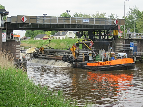Vanuit de Aduarder verte had ik al een opvallend vaartuig zien naderen. Pas op de plaats bij de hefbrug, wachtend op de bijzondere boot die water laat......