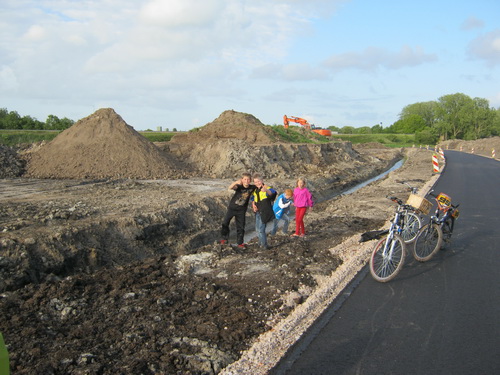 Aan de kant van de nieuwe kanaalweg is een groepje kinderen bezig de diepte van de nieuwe sloot te peilen.....