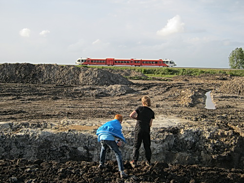Nee, er wordt niet naar de trein gegooid, die is te ver weg, visueel bedrog.