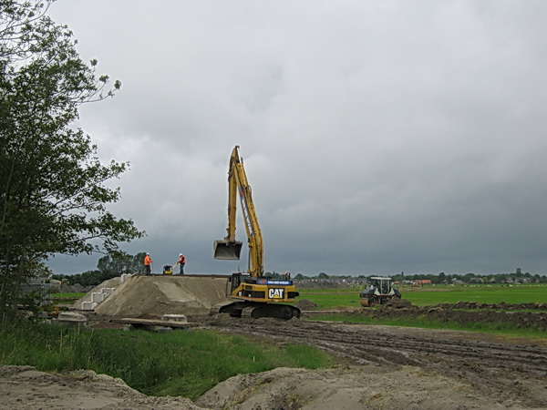 Wordt hier het speciale podium gebouwd voor de officiële aftrap van de N355-verleggingswerkzaamheden? Gaan Gedeputeerde Boumans, burgemeester Swart en Waterstaatdirecteur Schouwstra hier een optreden verzorgen, geheten "Startsein Werkzaamheden"? Nou nee, ik denk dat hier de noordelijke oeververbinding tussen nieuwe brug en N355 komt. Het werk is dus al lang begonnen, waarom die bobo's altijd te laat komen....