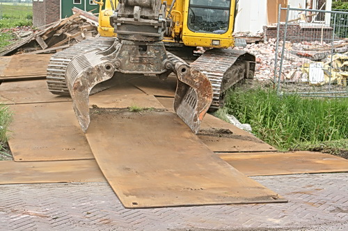 Ook deze klus gaat hem goed af! De kraanmachinist legt de rijplaten zorgvuldig op de goede plek!